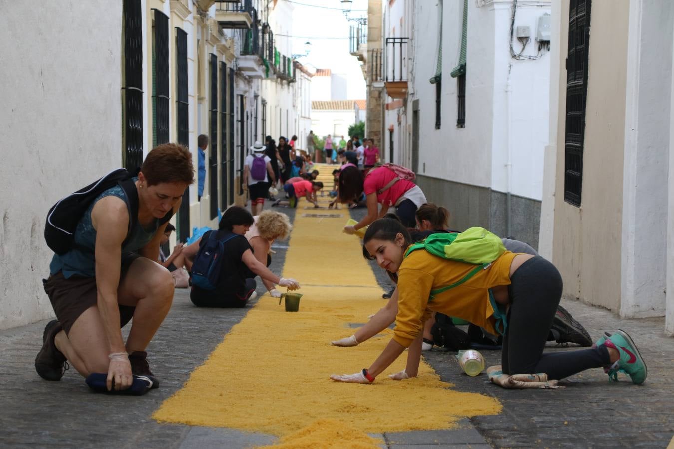 Las alfombras de sal embellecen y llenan de color, hoy, las calles de Jerez de los Caballeros con motivo de la festividad del Corpus Christi. Desde primera hora de la mañana, miembros de las cofradías y hermandades, Cáritas, grupos de catequesis, familias de los niños que han hecho este año la Primera Comunión, miembros de la Asociación de costaleros y costaleras de la Semana Santa jerezana, Ayuntamiento y vecinos han cubierto las principales calles del municipio con 6.250 kilos de sal teñida, plenas de color. A continuación, han disfrutado de una jornada de convivencia en la Casa de la Iglesia 'Cecilia de Arteaga'.