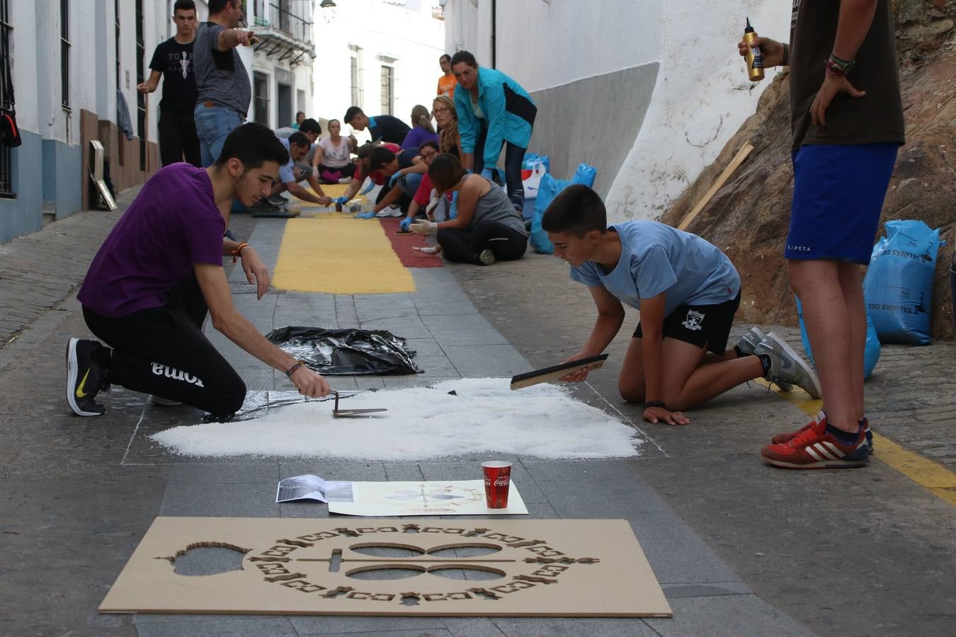 Las alfombras de sal embellecen y llenan de color, hoy, las calles de Jerez de los Caballeros con motivo de la festividad del Corpus Christi. Desde primera hora de la mañana, miembros de las cofradías y hermandades, Cáritas, grupos de catequesis, familias de los niños que han hecho este año la Primera Comunión, miembros de la Asociación de costaleros y costaleras de la Semana Santa jerezana, Ayuntamiento y vecinos han cubierto las principales calles del municipio con 6.250 kilos de sal teñida, plenas de color. A continuación, han disfrutado de una jornada de convivencia en la Casa de la Iglesia 'Cecilia de Arteaga'.