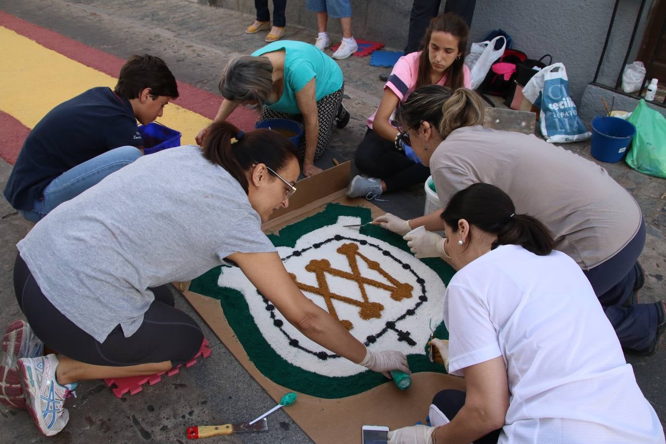Las alfombras de sal embellecen y llenan de color, hoy, las calles de Jerez de los Caballeros con motivo de la festividad del Corpus Christi. Desde primera hora de la mañana, miembros de las cofradías y hermandades, Cáritas, grupos de catequesis, familias de los niños que han hecho este año la Primera Comunión, miembros de la Asociación de costaleros y costaleras de la Semana Santa jerezana, Ayuntamiento y vecinos han cubierto las principales calles del municipio con 6.250 kilos de sal teñida, plenas de color. A continuación, han disfrutado de una jornada de convivencia en la Casa de la Iglesia 'Cecilia de Arteaga'.