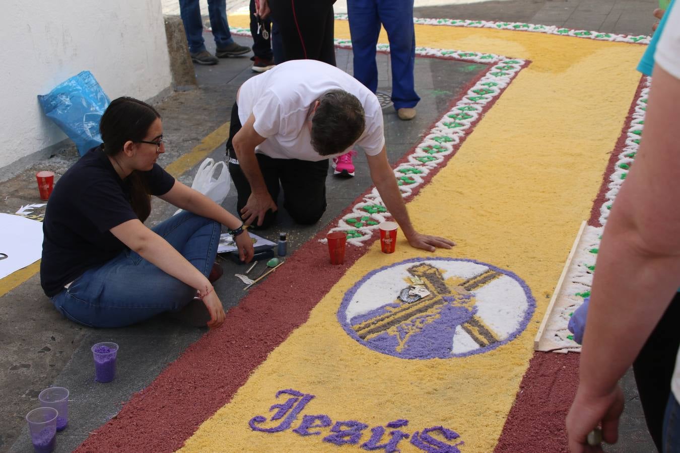 Las alfombras de sal embellecen y llenan de color, hoy, las calles de Jerez de los Caballeros con motivo de la festividad del Corpus Christi. Desde primera hora de la mañana, miembros de las cofradías y hermandades, Cáritas, grupos de catequesis, familias de los niños que han hecho este año la Primera Comunión, miembros de la Asociación de costaleros y costaleras de la Semana Santa jerezana, Ayuntamiento y vecinos han cubierto las principales calles del municipio con 6.250 kilos de sal teñida, plenas de color. A continuación, han disfrutado de una jornada de convivencia en la Casa de la Iglesia 'Cecilia de Arteaga'.