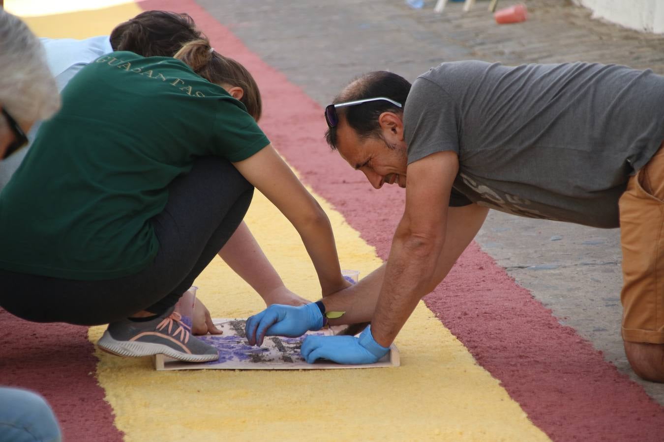 Las alfombras de sal embellecen y llenan de color, hoy, las calles de Jerez de los Caballeros con motivo de la festividad del Corpus Christi. Desde primera hora de la mañana, miembros de las cofradías y hermandades, Cáritas, grupos de catequesis, familias de los niños que han hecho este año la Primera Comunión, miembros de la Asociación de costaleros y costaleras de la Semana Santa jerezana, Ayuntamiento y vecinos han cubierto las principales calles del municipio con 6.250 kilos de sal teñida, plenas de color. A continuación, han disfrutado de una jornada de convivencia en la Casa de la Iglesia 'Cecilia de Arteaga'.