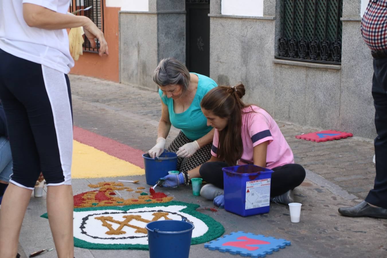 Las alfombras de sal embellecen y llenan de color, hoy, las calles de Jerez de los Caballeros con motivo de la festividad del Corpus Christi. Desde primera hora de la mañana, miembros de las cofradías y hermandades, Cáritas, grupos de catequesis, familias de los niños que han hecho este año la Primera Comunión, miembros de la Asociación de costaleros y costaleras de la Semana Santa jerezana, Ayuntamiento y vecinos han cubierto las principales calles del municipio con 6.250 kilos de sal teñida, plenas de color. A continuación, han disfrutado de una jornada de convivencia en la Casa de la Iglesia 'Cecilia de Arteaga'.