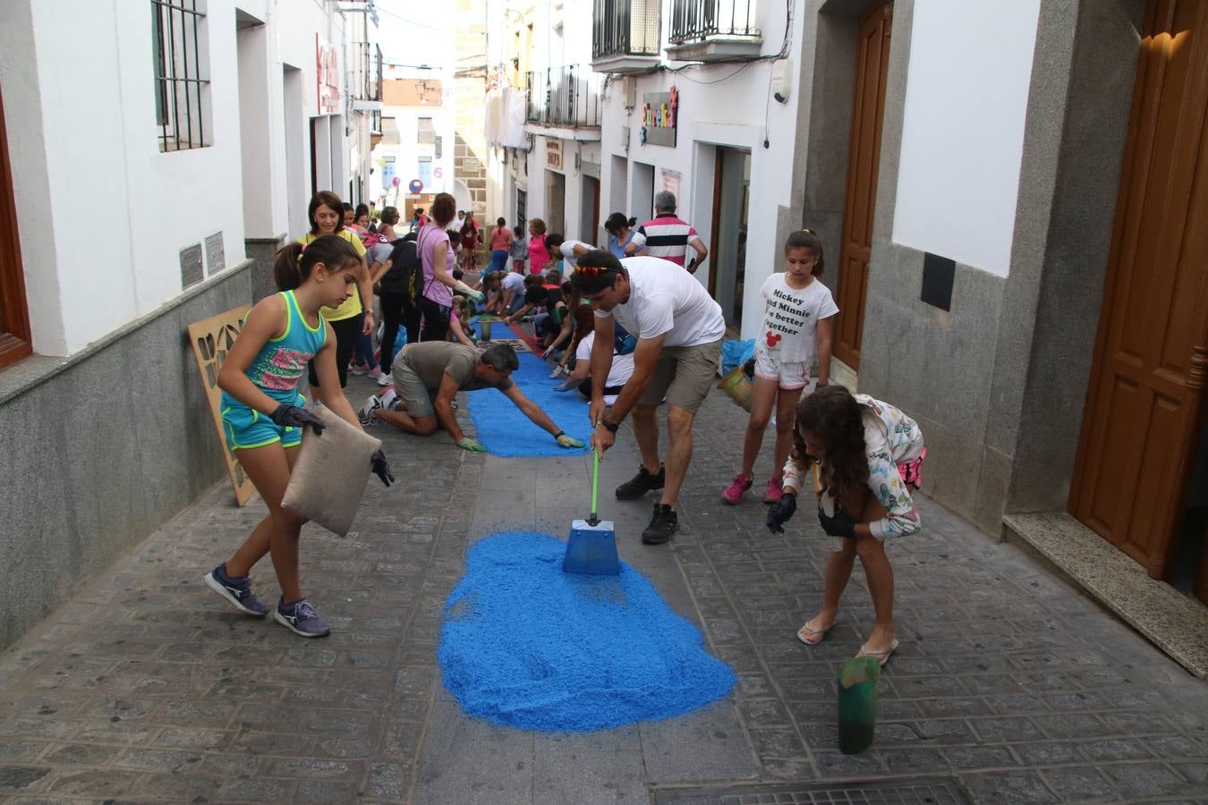 Las alfombras de sal embellecen y llenan de color, hoy, las calles de Jerez de los Caballeros con motivo de la festividad del Corpus Christi. Desde primera hora de la mañana, miembros de las cofradías y hermandades, Cáritas, grupos de catequesis, familias de los niños que han hecho este año la Primera Comunión, miembros de la Asociación de costaleros y costaleras de la Semana Santa jerezana, Ayuntamiento y vecinos han cubierto las principales calles del municipio con 6.250 kilos de sal teñida, plenas de color. A continuación, han disfrutado de una jornada de convivencia en la Casa de la Iglesia 'Cecilia de Arteaga'.