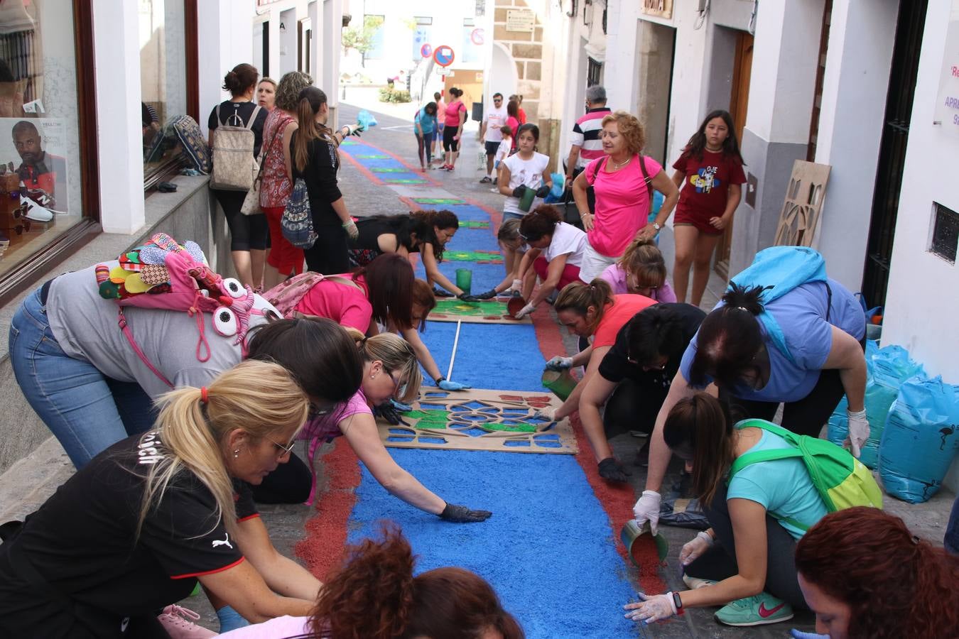 Las alfombras de sal embellecen y llenan de color, hoy, las calles de Jerez de los Caballeros con motivo de la festividad del Corpus Christi. Desde primera hora de la mañana, miembros de las cofradías y hermandades, Cáritas, grupos de catequesis, familias de los niños que han hecho este año la Primera Comunión, miembros de la Asociación de costaleros y costaleras de la Semana Santa jerezana, Ayuntamiento y vecinos han cubierto las principales calles del municipio con 6.250 kilos de sal teñida, plenas de color. A continuación, han disfrutado de una jornada de convivencia en la Casa de la Iglesia 'Cecilia de Arteaga'.