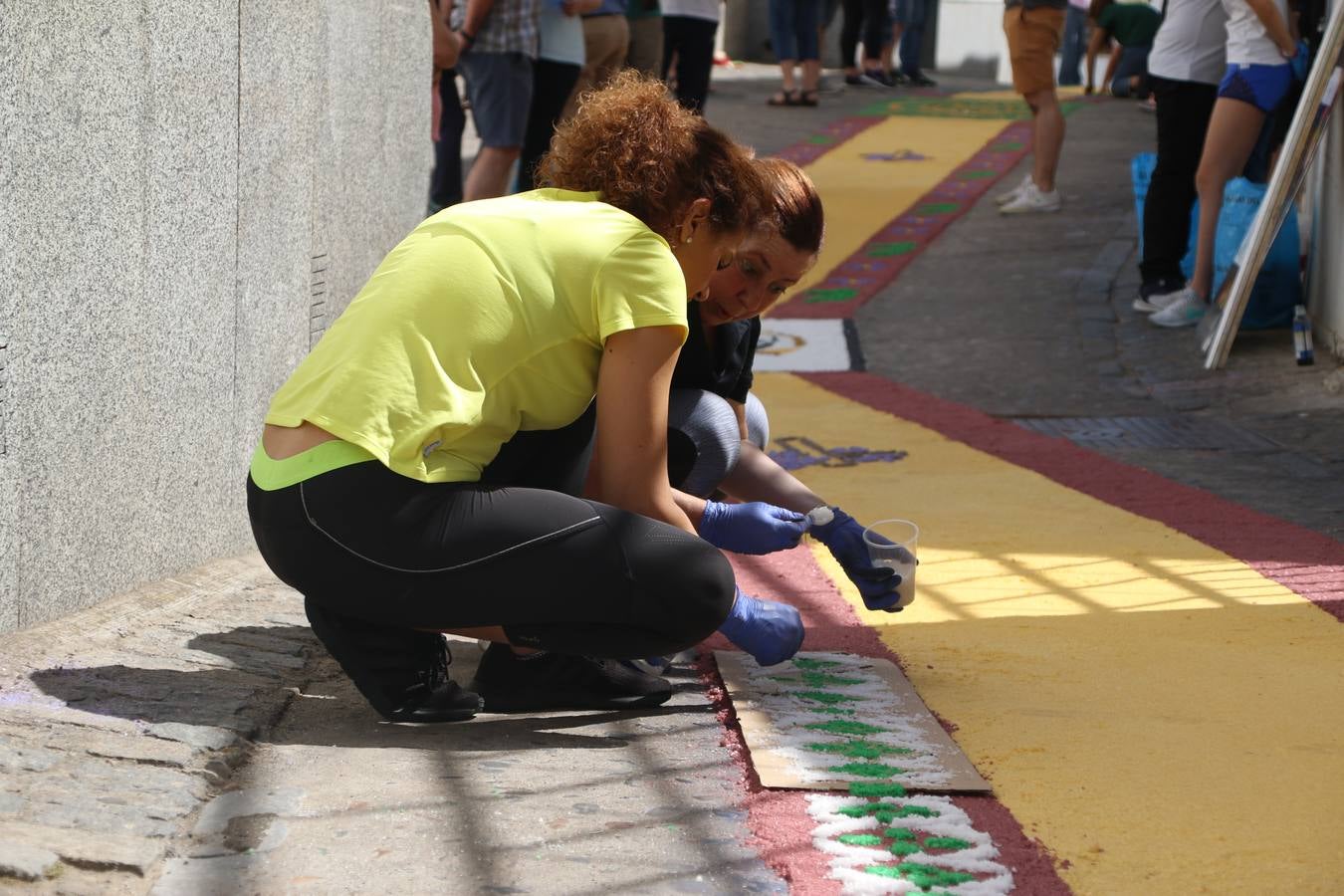 Las alfombras de sal embellecen y llenan de color, hoy, las calles de Jerez de los Caballeros con motivo de la festividad del Corpus Christi. Desde primera hora de la mañana, miembros de las cofradías y hermandades, Cáritas, grupos de catequesis, familias de los niños que han hecho este año la Primera Comunión, miembros de la Asociación de costaleros y costaleras de la Semana Santa jerezana, Ayuntamiento y vecinos han cubierto las principales calles del municipio con 6.250 kilos de sal teñida, plenas de color. A continuación, han disfrutado de una jornada de convivencia en la Casa de la Iglesia 'Cecilia de Arteaga'.