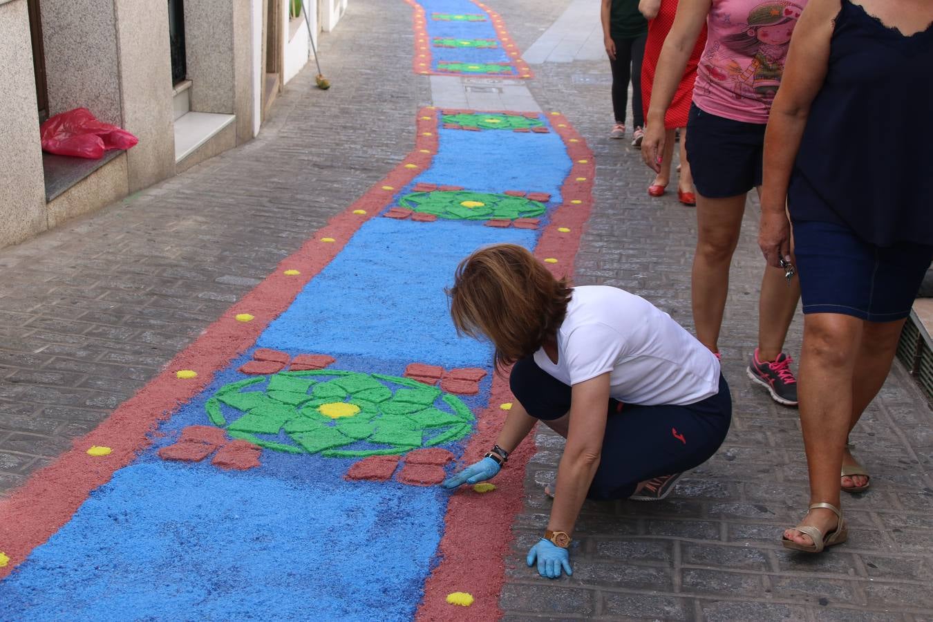Las alfombras de sal embellecen y llenan de color, hoy, las calles de Jerez de los Caballeros con motivo de la festividad del Corpus Christi. Desde primera hora de la mañana, miembros de las cofradías y hermandades, Cáritas, grupos de catequesis, familias de los niños que han hecho este año la Primera Comunión, miembros de la Asociación de costaleros y costaleras de la Semana Santa jerezana, Ayuntamiento y vecinos han cubierto las principales calles del municipio con 6.250 kilos de sal teñida, plenas de color. A continuación, han disfrutado de una jornada de convivencia en la Casa de la Iglesia 'Cecilia de Arteaga'.