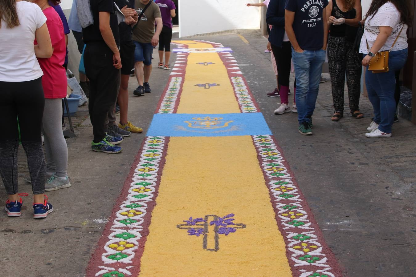 Las alfombras de sal embellecen y llenan de color, hoy, las calles de Jerez de los Caballeros con motivo de la festividad del Corpus Christi. Desde primera hora de la mañana, miembros de las cofradías y hermandades, Cáritas, grupos de catequesis, familias de los niños que han hecho este año la Primera Comunión, miembros de la Asociación de costaleros y costaleras de la Semana Santa jerezana, Ayuntamiento y vecinos han cubierto las principales calles del municipio con 6.250 kilos de sal teñida, plenas de color. A continuación, han disfrutado de una jornada de convivencia en la Casa de la Iglesia 'Cecilia de Arteaga'.