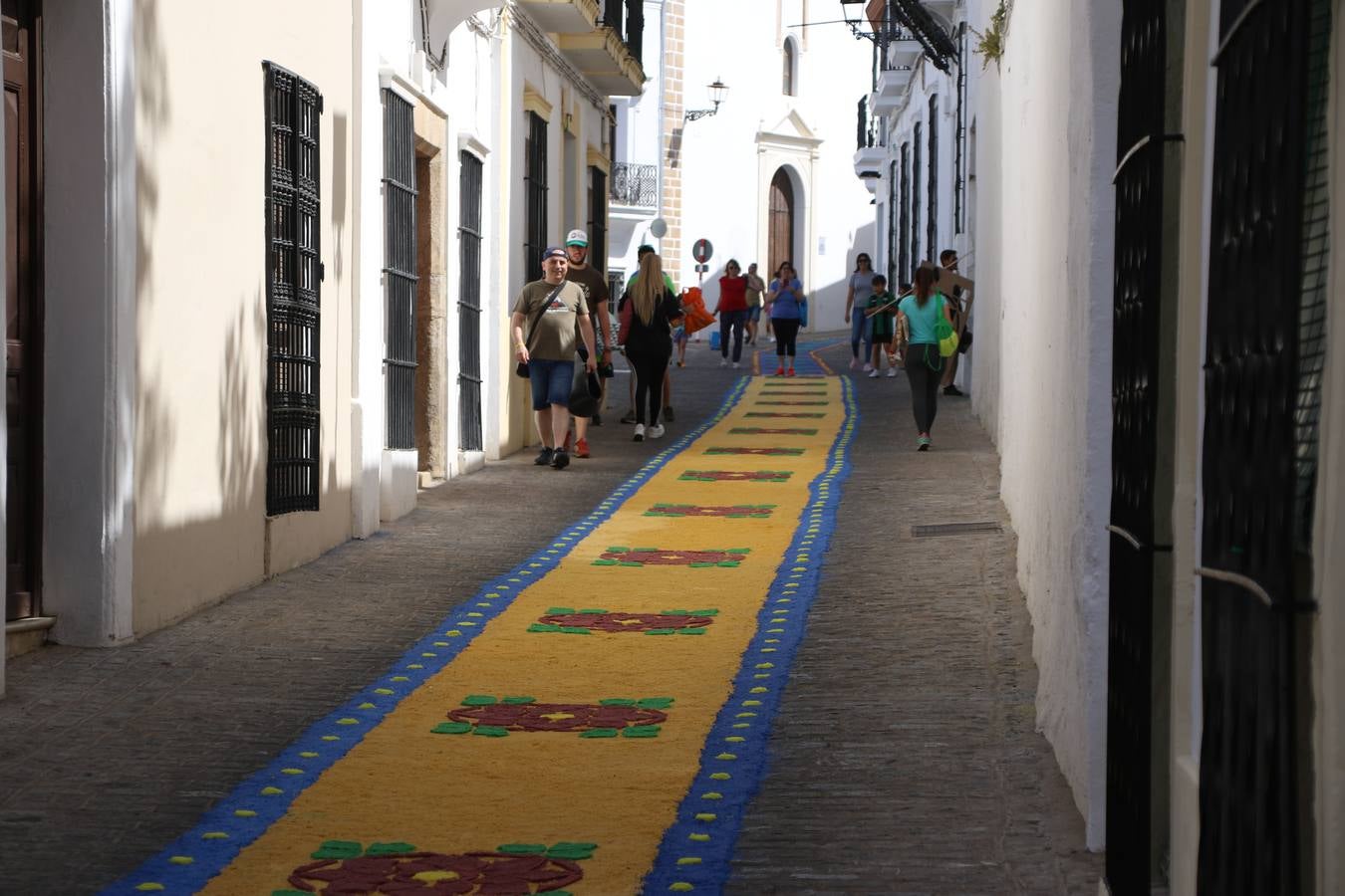Las alfombras de sal embellecen y llenan de color, hoy, las calles de Jerez de los Caballeros con motivo de la festividad del Corpus Christi. Desde primera hora de la mañana, miembros de las cofradías y hermandades, Cáritas, grupos de catequesis, familias de los niños que han hecho este año la Primera Comunión, miembros de la Asociación de costaleros y costaleras de la Semana Santa jerezana, Ayuntamiento y vecinos han cubierto las principales calles del municipio con 6.250 kilos de sal teñida, plenas de color. A continuación, han disfrutado de una jornada de convivencia en la Casa de la Iglesia 'Cecilia de Arteaga'.