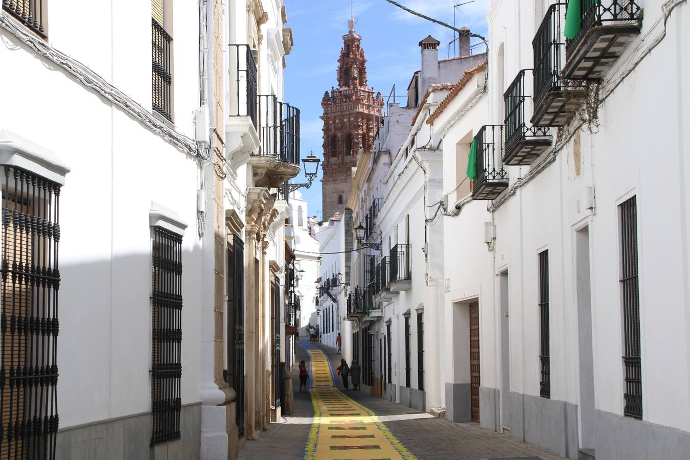 Las alfombras de sal embellecen y llenan de color, hoy, las calles de Jerez de los Caballeros con motivo de la festividad del Corpus Christi. Desde primera hora de la mañana, miembros de las cofradías y hermandades, Cáritas, grupos de catequesis, familias de los niños que han hecho este año la Primera Comunión, miembros de la Asociación de costaleros y costaleras de la Semana Santa jerezana, Ayuntamiento y vecinos han cubierto las principales calles del municipio con 6.250 kilos de sal teñida, plenas de color. A continuación, han disfrutado de una jornada de convivencia en la Casa de la Iglesia 'Cecilia de Arteaga'.