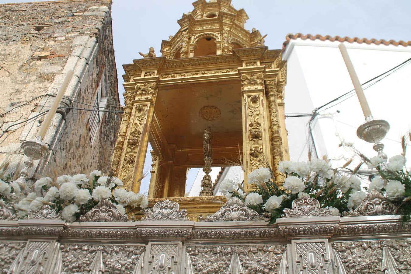 Jerez de los Caballeros celebró ayer la festividad del Corpus Christi en medio de un ambiente de solemnidad y convivencia del que fueron partícipes cientos de personas.La iglesia visigoda de Santa María de la Encarnación, llena de fieles, acogió la celebración de la Eucaristía que dió paso a la procesión acompañando la Santa Custodia en el magnífico templete de la iglesia de San Miguel, sobre las andas de la Virgen de Aguasantas y portada por costaleros y costaleras de la recién Asociación creada en esta ciudad. El párroco, Antonio María Rejano, destacó la significación de esta procesión, lamás grande, dijo, «porque Jesús sale a nuestras vidas, a nuestro encuentro y nosotros le acompañamos». Al término de la misa, incidió en el agradecimiento a todas las personas que han participado para hacer posible su desarrollo, trabajando desde la jornada del sábado en la elaboración de las preciosas alfombras de sal teñida de colores, que lucieron en las calles del centro de Jerez. El agradecimiento fue especial para los padres y madres de los niños y niñas que han hecho la Primera Comunión, para éstos mismos, también para catequistas, Cofradías y Hermandades, la Asociación del costaleros y costaleras de la Semana Santa de Jerez de los Caballeros, Ayuntamiento, Policía Local, grupos y personas de la parroquia.Autoridades civiles en representación del Ayuntamiento, Policía Local y Guardia Civil, acompañaron el desarrollo de la procesión junto a representantes de todas las cofradías y hermandades jerezanas y el protagonismo de los más de 80 niños y niñas que este año han celebrado su Primera Comunión.  A lo largo de todo el recorrido se instalaron distintos altares, también con la colaboración de vecinos y centros como la Residencia de Mayores Hernando de Soto. Los magníficos sones de la Agrupación Musical 'Nuestro Padre Jesús Nazareno' coronaron esta hermosa procesión.