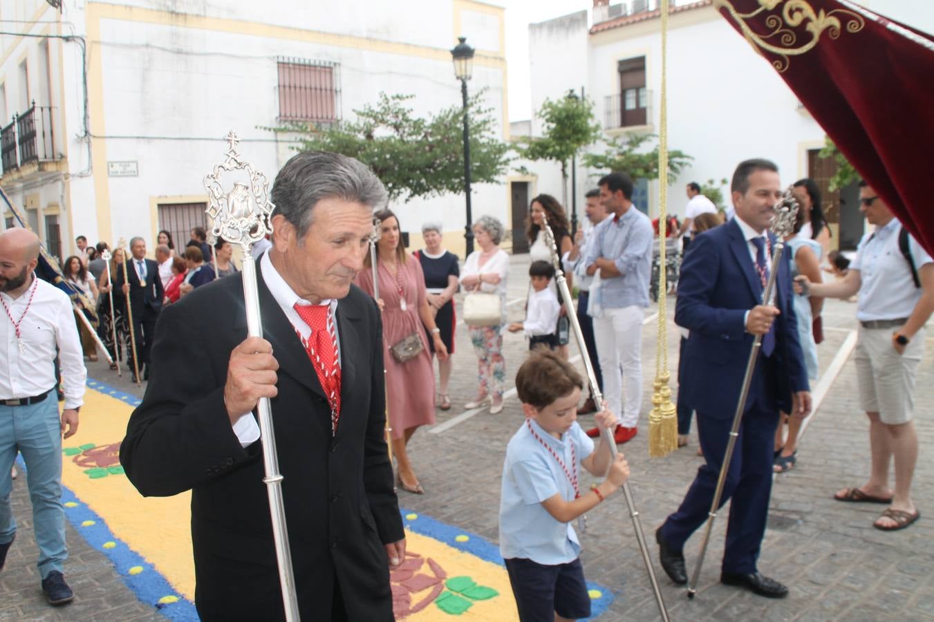 Jerez de los Caballeros celebró ayer la festividad del Corpus Christi en medio de un ambiente de solemnidad y convivencia del que fueron partícipes cientos de personas.La iglesia visigoda de Santa María de la Encarnación, llena de fieles, acogió la celebración de la Eucaristía que dió paso a la procesión acompañando la Santa Custodia en el magnífico templete de la iglesia de San Miguel, sobre las andas de la Virgen de Aguasantas y portada por costaleros y costaleras de la recién Asociación creada en esta ciudad. El párroco, Antonio María Rejano, destacó la significación de esta procesión, lamás grande, dijo, «porque Jesús sale a nuestras vidas, a nuestro encuentro y nosotros le acompañamos». Al término de la misa, incidió en el agradecimiento a todas las personas que han participado para hacer posible su desarrollo, trabajando desde la jornada del sábado en la elaboración de las preciosas alfombras de sal teñida de colores, que lucieron en las calles del centro de Jerez. El agradecimiento fue especial para los padres y madres de los niños y niñas que han hecho la Primera Comunión, para éstos mismos, también para catequistas, Cofradías y Hermandades, la Asociación del costaleros y costaleras de la Semana Santa de Jerez de los Caballeros, Ayuntamiento, Policía Local, grupos y personas de la parroquia.Autoridades civiles en representación del Ayuntamiento, Policía Local y Guardia Civil, acompañaron el desarrollo de la procesión junto a representantes de todas las cofradías y hermandades jerezanas y el protagonismo de los más de 80 niños y niñas que este año han celebrado su Primera Comunión.  A lo largo de todo el recorrido se instalaron distintos altares, también con la colaboración de vecinos y centros como la Residencia de Mayores Hernando de Soto. Los magníficos sones de la Agrupación Musical 'Nuestro Padre Jesús Nazareno' coronaron esta hermosa procesión.