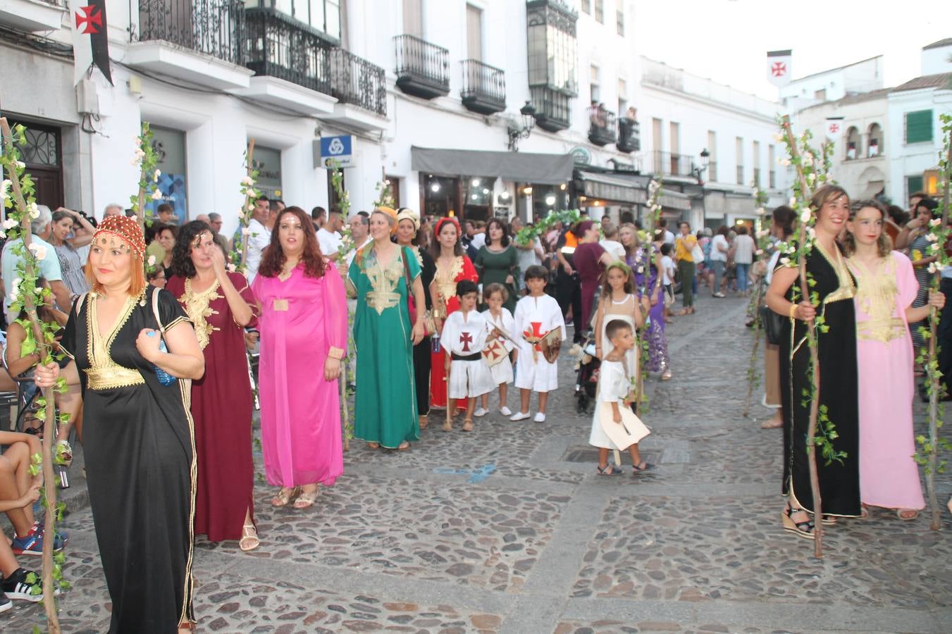 La participación popular fue nuevo protagonista del desfile teatralizado que anoche inauguró el grueso de la programación del XVI Festival Templario, invitando a propios y visitantes a revivir un pasado de leyenda, concretamente el siglo en el que La Orden del Temple marcó la vida de esta ciudad, en la que tuvo una de sus principales Encomiendas, siendo además el último reducto de Los Templarios en los reinos de España.La Asociación juvenil y cultural 'La Trouppe' estuvo al frente de la coordinación de dicho desfile que llenó de ambiente y animación las calles y plazas del centro histórico de Jerez de los Caballeros, llenas de público y engalanadas para la ocasión con pendones con la cruz templaria y otros elementos referentes a la cultura árabe que dejó su impronta en aquella época. Destacó la participación de más de 60 niñas que pusieron alegría con sus bailes a este pasacalle, junto a personajes fantásticos en zancos, la melodía de la Asociación Musical de Jerez de los Caballeros y la participación de asociaciones, como la del Belén 'Santa Ángela', Euexia Rural, además de los caballeros del campamento medieval a cargo de Cabalbur y de manera especial, la implicación de numerosos vecinos de todas las edades que desfilaron ataviados con indumentaria de la época dando vida a esta celebración.