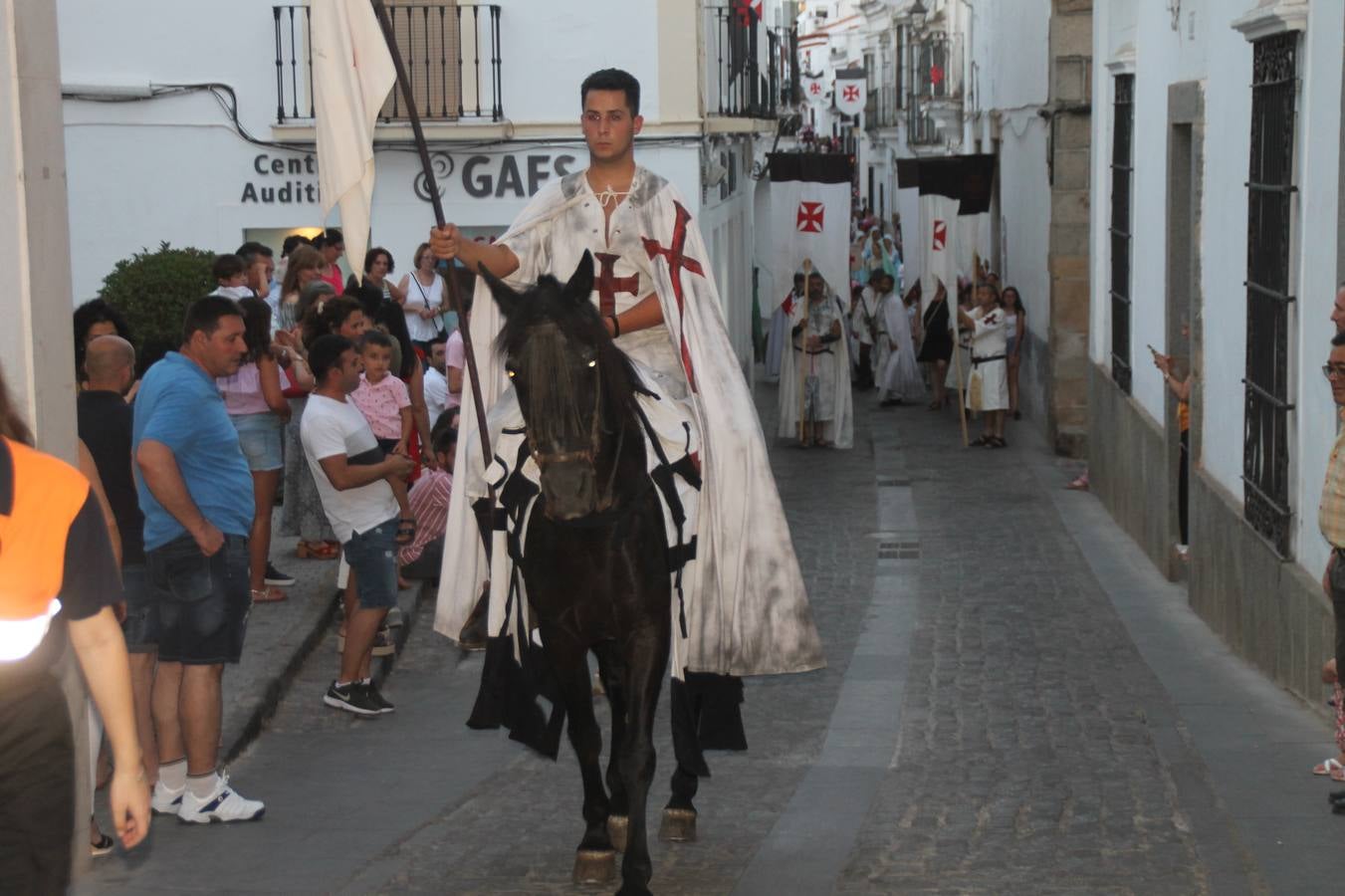 La participación popular fue nuevo protagonista del desfile teatralizado que anoche inauguró el grueso de la programación del XVI Festival Templario, invitando a propios y visitantes a revivir un pasado de leyenda, concretamente el siglo en el que La Orden del Temple marcó la vida de esta ciudad, en la que tuvo una de sus principales Encomiendas, siendo además el último reducto de Los Templarios en los reinos de España.La Asociación juvenil y cultural 'La Trouppe' estuvo al frente de la coordinación de dicho desfile que llenó de ambiente y animación las calles y plazas del centro histórico de Jerez de los Caballeros, llenas de público y engalanadas para la ocasión con pendones con la cruz templaria y otros elementos referentes a la cultura árabe que dejó su impronta en aquella época. Destacó la participación de más de 60 niñas que pusieron alegría con sus bailes a este pasacalle, junto a personajes fantásticos en zancos, la melodía de la Asociación Musical de Jerez de los Caballeros y la participación de asociaciones, como la del Belén 'Santa Ángela', Euexia Rural, además de los caballeros del campamento medieval a cargo de Cabalbur y de manera especial, la implicación de numerosos vecinos de todas las edades que desfilaron ataviados con indumentaria de la época dando vida a esta celebración.