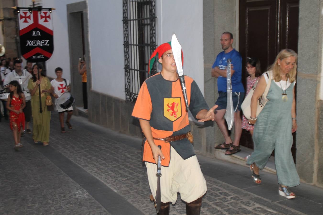 La participación popular fue nuevo protagonista del desfile teatralizado que anoche inauguró el grueso de la programación del XVI Festival Templario, invitando a propios y visitantes a revivir un pasado de leyenda, concretamente el siglo en el que La Orden del Temple marcó la vida de esta ciudad, en la que tuvo una de sus principales Encomiendas, siendo además el último reducto de Los Templarios en los reinos de España.La Asociación juvenil y cultural 'La Trouppe' estuvo al frente de la coordinación de dicho desfile que llenó de ambiente y animación las calles y plazas del centro histórico de Jerez de los Caballeros, llenas de público y engalanadas para la ocasión con pendones con la cruz templaria y otros elementos referentes a la cultura árabe que dejó su impronta en aquella época. Destacó la participación de más de 60 niñas que pusieron alegría con sus bailes a este pasacalle, junto a personajes fantásticos en zancos, la melodía de la Asociación Musical de Jerez de los Caballeros y la participación de asociaciones, como la del Belén 'Santa Ángela', Euexia Rural, además de los caballeros del campamento medieval a cargo de Cabalbur y de manera especial, la implicación de numerosos vecinos de todas las edades que desfilaron ataviados con indumentaria de la época dando vida a esta celebración.