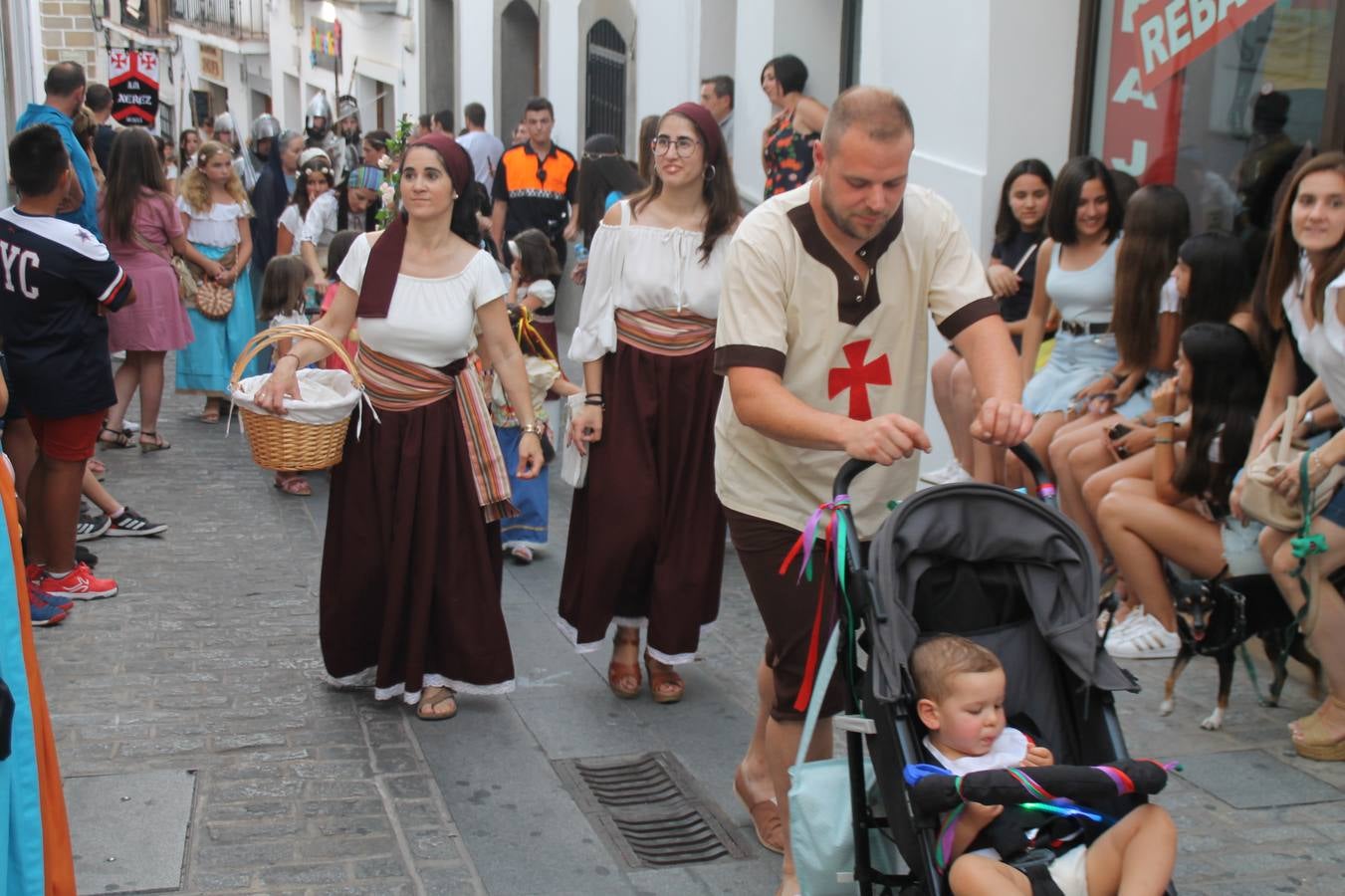 La participación popular fue nuevo protagonista del desfile teatralizado que anoche inauguró el grueso de la programación del XVI Festival Templario, invitando a propios y visitantes a revivir un pasado de leyenda, concretamente el siglo en el que La Orden del Temple marcó la vida de esta ciudad, en la que tuvo una de sus principales Encomiendas, siendo además el último reducto de Los Templarios en los reinos de España.La Asociación juvenil y cultural 'La Trouppe' estuvo al frente de la coordinación de dicho desfile que llenó de ambiente y animación las calles y plazas del centro histórico de Jerez de los Caballeros, llenas de público y engalanadas para la ocasión con pendones con la cruz templaria y otros elementos referentes a la cultura árabe que dejó su impronta en aquella época. Destacó la participación de más de 60 niñas que pusieron alegría con sus bailes a este pasacalle, junto a personajes fantásticos en zancos, la melodía de la Asociación Musical de Jerez de los Caballeros y la participación de asociaciones, como la del Belén 'Santa Ángela', Euexia Rural, además de los caballeros del campamento medieval a cargo de Cabalbur y de manera especial, la implicación de numerosos vecinos de todas las edades que desfilaron ataviados con indumentaria de la época dando vida a esta celebración.