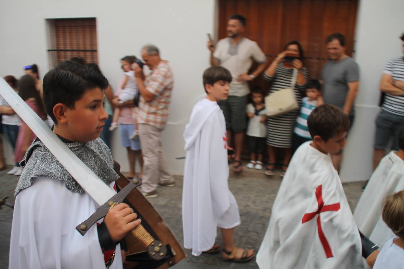 La participación popular fue nuevo protagonista del desfile teatralizado que anoche inauguró el grueso de la programación del XVI Festival Templario, invitando a propios y visitantes a revivir un pasado de leyenda, concretamente el siglo en el que La Orden del Temple marcó la vida de esta ciudad, en la que tuvo una de sus principales Encomiendas, siendo además el último reducto de Los Templarios en los reinos de España.La Asociación juvenil y cultural 'La Trouppe' estuvo al frente de la coordinación de dicho desfile que llenó de ambiente y animación las calles y plazas del centro histórico de Jerez de los Caballeros, llenas de público y engalanadas para la ocasión con pendones con la cruz templaria y otros elementos referentes a la cultura árabe que dejó su impronta en aquella época. Destacó la participación de más de 60 niñas que pusieron alegría con sus bailes a este pasacalle, junto a personajes fantásticos en zancos, la melodía de la Asociación Musical de Jerez de los Caballeros y la participación de asociaciones, como la del Belén 'Santa Ángela', Euexia Rural, además de los caballeros del campamento medieval a cargo de Cabalbur y de manera especial, la implicación de numerosos vecinos de todas las edades que desfilaron ataviados con indumentaria de la época dando vida a esta celebración.