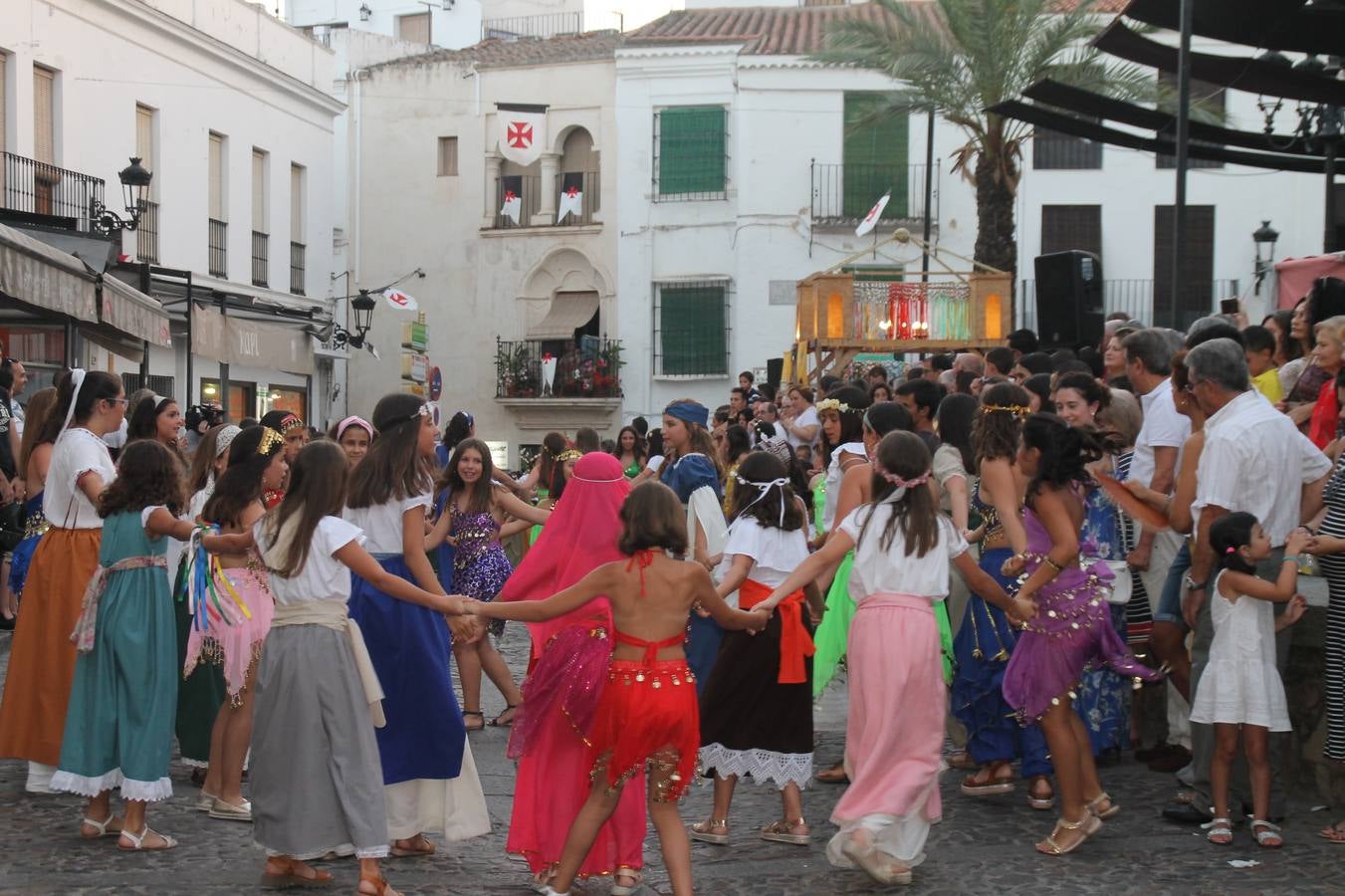 La participación popular fue nuevo protagonista del desfile teatralizado que anoche inauguró el grueso de la programación del XVI Festival Templario, invitando a propios y visitantes a revivir un pasado de leyenda, concretamente el siglo en el que La Orden del Temple marcó la vida de esta ciudad, en la que tuvo una de sus principales Encomiendas, siendo además el último reducto de Los Templarios en los reinos de España.La Asociación juvenil y cultural 'La Trouppe' estuvo al frente de la coordinación de dicho desfile que llenó de ambiente y animación las calles y plazas del centro histórico de Jerez de los Caballeros, llenas de público y engalanadas para la ocasión con pendones con la cruz templaria y otros elementos referentes a la cultura árabe que dejó su impronta en aquella época. Destacó la participación de más de 60 niñas que pusieron alegría con sus bailes a este pasacalle, junto a personajes fantásticos en zancos, la melodía de la Asociación Musical de Jerez de los Caballeros y la participación de asociaciones, como la del Belén 'Santa Ángela', Euexia Rural, además de los caballeros del campamento medieval a cargo de Cabalbur y de manera especial, la implicación de numerosos vecinos de todas las edades que desfilaron ataviados con indumentaria de la época dando vida a esta celebración.