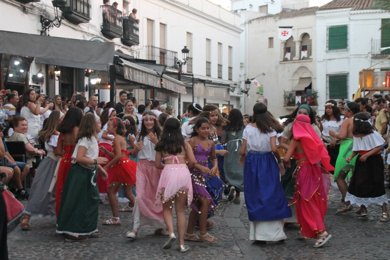 La participación popular fue nuevo protagonista del desfile teatralizado que anoche inauguró el grueso de la programación del XVI Festival Templario, invitando a propios y visitantes a revivir un pasado de leyenda, concretamente el siglo en el que La Orden del Temple marcó la vida de esta ciudad, en la que tuvo una de sus principales Encomiendas, siendo además el último reducto de Los Templarios en los reinos de España.La Asociación juvenil y cultural 'La Trouppe' estuvo al frente de la coordinación de dicho desfile que llenó de ambiente y animación las calles y plazas del centro histórico de Jerez de los Caballeros, llenas de público y engalanadas para la ocasión con pendones con la cruz templaria y otros elementos referentes a la cultura árabe que dejó su impronta en aquella época. Destacó la participación de más de 60 niñas que pusieron alegría con sus bailes a este pasacalle, junto a personajes fantásticos en zancos, la melodía de la Asociación Musical de Jerez de los Caballeros y la participación de asociaciones, como la del Belén 'Santa Ángela', Euexia Rural, además de los caballeros del campamento medieval a cargo de Cabalbur y de manera especial, la implicación de numerosos vecinos de todas las edades que desfilaron ataviados con indumentaria de la época dando vida a esta celebración.
