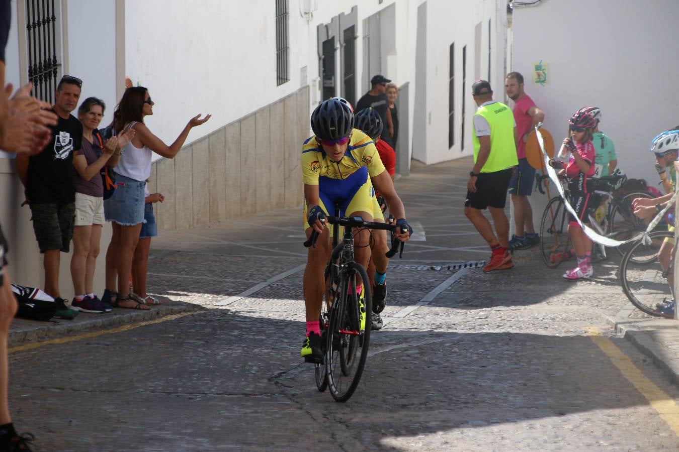 El barrio de 'Santa Catalina' de Jerez de los Caballeros ha acogido, esta mañana, la tercera prueba del Gran Premio Diputación de Badajoz 'Copa Escuelas de ciclismo en carretera', organizada por el Club Ciclista Jerez de los Caballeros y la Federación Extremeña de Ciclismo.Una competición de ciclismo que, como ya adelantó HOY Jerez, fue creada por la Federación Extremeña de Ciclismo con el objetivo de fomentar y seguir practicando deporte cuando ya han terminado todos los circuitos que se celebran durante el curso académico. En la citada prueba, han participado diferentes categorías: cadete, promesa, junior, principiante, alevín e infantil.Juan Luis Soriano, presidente del Club Ciclista Jerez, ha manifestado su satisfacción por el buen desarrollo de la jornada, «este tipo de pruebas son fundamentales para hacer cantera y promover este deporte entre los más pequeños».