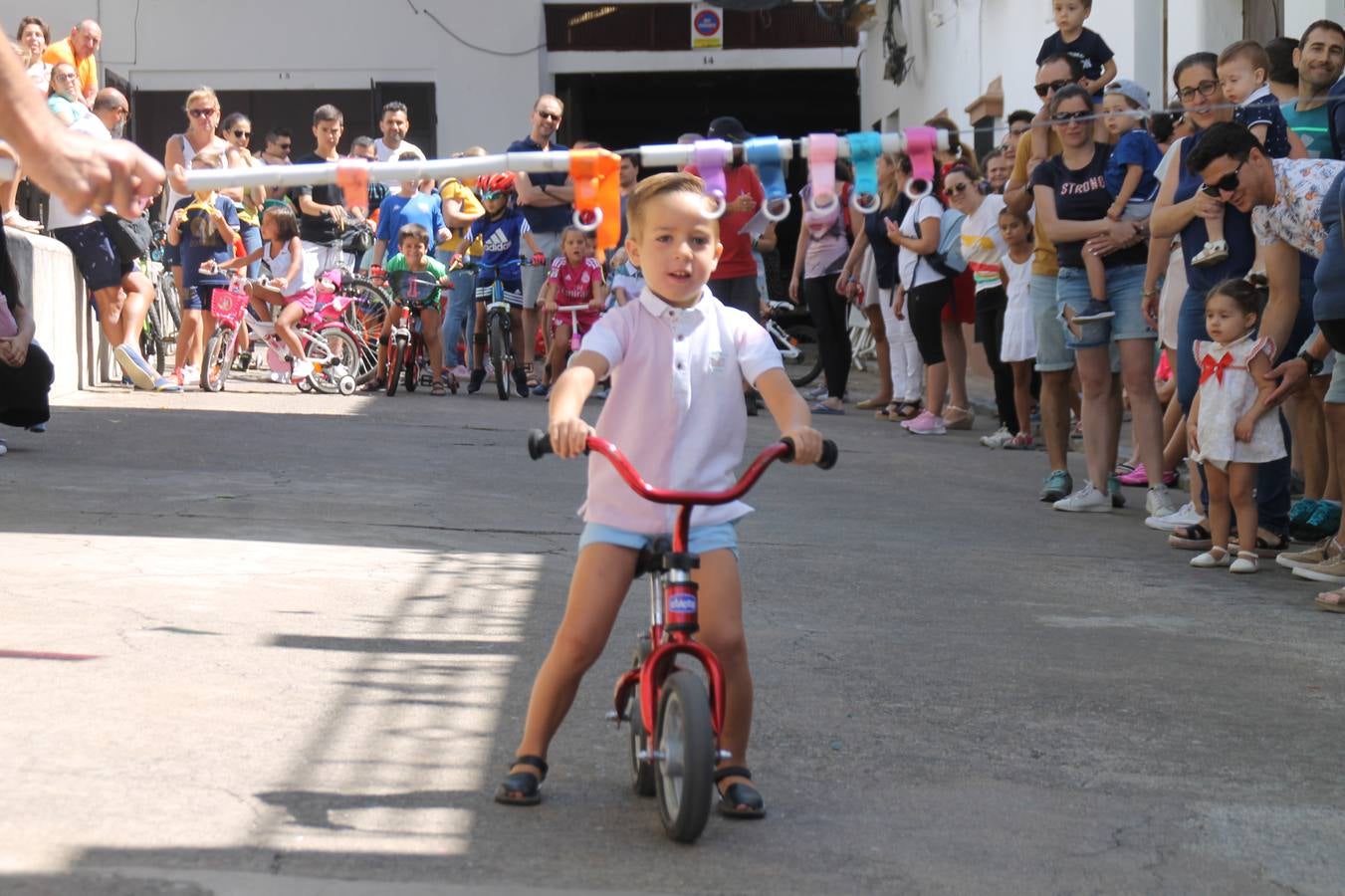 El barrio de Los Mártires ha vuelto a llenarse de fiesta, juegos y sabores típicos este fin de semana con la celebración de su tradicional 'Velá' que este año se ha vivido durante la noche del sábado y la mañana y primeras horas de la tarde del domingo.Los más pequeños del barrio callonco y de otros barrios de Jerez fueron protagonistas anoche con actividades como una exhibición de playbacks. El momento más especial fue la actuación del grupo jerezano 'Camerata Bolero' que, con un pedacito de su corazón musical prendido del Llano de Los Mártires donde ya ha deleitado con su música a sus paisanos en distintas ocasiones, anoche volvía a cantar al amor y a la vida, compartiendo la dicha de sus 25 años de andadura con sus más fieles seguidores. Con dos fantásticas voces femeninas como parte del grupo, María Jesús Méndez y María del Carmen Gordillo, Camerata Bolero esquivó la línea del tiempo con canciones eternas que solo entienden de sentimiento. El público regaló a sus componentes su aplauso y a su afecto.La ermita de los Santos Mártires ha sido testigo hoy domingo, con la luz del día, de la algarabía y la fiesta. El repique de sus campanas anunciaba por la mañana la celebración de la misa en acción de gracias, recordando la larga tradición de esta 'Velá', con más de 200 años de historia, y el singular desfile de gigantes y cabezudos invitaba a los niños y niñas a participar y a disfrutar de los juegos populares: carrera de cintas en bicicletas, carrera de sacos, el maratón callonco, y a divertirse también con distintas atracciones de agua y un cañón de espuma. La venta de los ricos dulces martileros y el servicio de barra atendido por los vecinos del barrio han puesto sabor a la celebración.