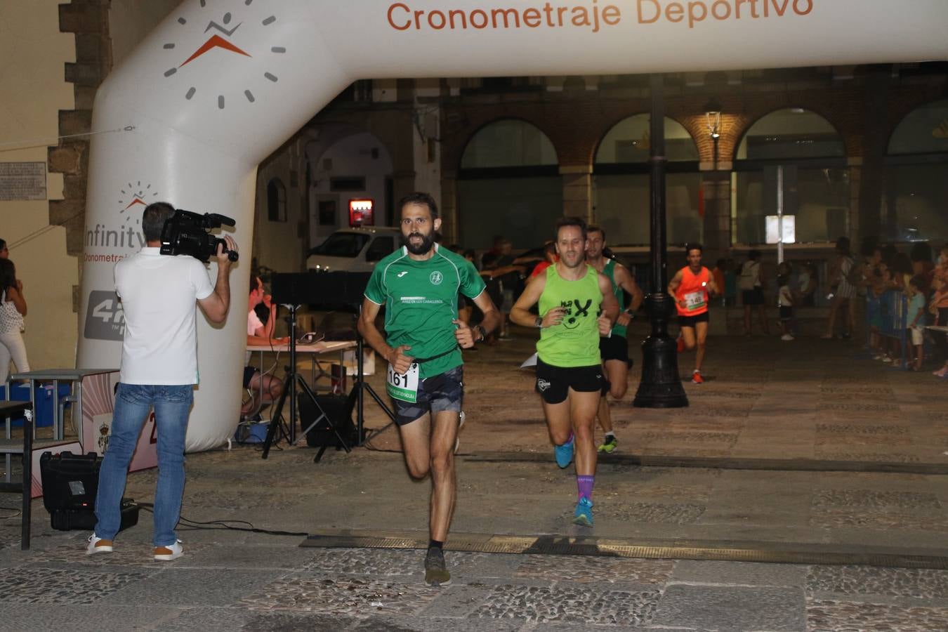 La Plaza de España de Jerez de los Caballeros acogió, ayer, la V Carrera Popular Nocturna 'Recorriendo el Medievo', organizada por el Ayuntamiento del municipio con la colaboración del Plan de Dinamización Deportiva de la Mancomunidad Sierra Suroeste. Las principales calles del municipio volvieron a convertirse en el mejor escenario para el desarrollo de esta prueba deportiva que, año tras año, se consolida como una de las citas más destacadas del calendario estival jerezano y en la que la solidaridad, también, está muy presente. Así, se lograron recaudar 153 kilos y 22 euros que irán destinados al almacén de alimentos que gestiona la Asamblea local de Cruz Roja en el municipio.En esta edición, han participado unos 200 corredores de la localidad y alrededores, siendo Manuel Gómez Lucas y Tina María Ramos, vencedores de la clasificación general.