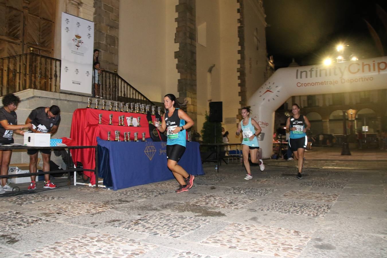La Plaza de España de Jerez de los Caballeros acogió, ayer, la V Carrera Popular Nocturna 'Recorriendo el Medievo', organizada por el Ayuntamiento del municipio con la colaboración del Plan de Dinamización Deportiva de la Mancomunidad Sierra Suroeste. Las principales calles del municipio volvieron a convertirse en el mejor escenario para el desarrollo de esta prueba deportiva que, año tras año, se consolida como una de las citas más destacadas del calendario estival jerezano y en la que la solidaridad, también, está muy presente. Así, se lograron recaudar 153 kilos y 22 euros que irán destinados al almacén de alimentos que gestiona la Asamblea local de Cruz Roja en el municipio.En esta edición, han participado unos 200 corredores de la localidad y alrededores, siendo Manuel Gómez Lucas y Tina María Ramos, vencedores de la clasificación general.