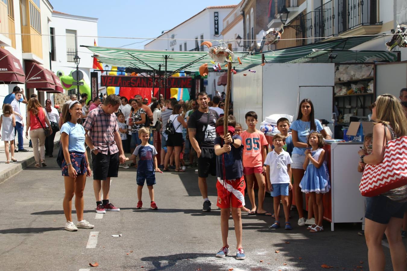 El popular 'Barrio Alto' vuelve, un año más, a lucir engalanado con motivo de la festividad de San Bartolomé, patrón de Jerez de los Caballeros. Ayer, vivía la primera jornada de su tradicional «velá» en la que el «diablo» fue el principal protagonista. Esta mañana, la fiesta continuaba con la procesión y los juegos populares. Autoridades civiles y religiosas, miembros de las diferentes hermandades y cofradías del municipio, la Agrupación Musical 'Nuestro Padre Jesús Nazareno', la Asociación Musical Jerez de los Caballeros y numerosos vecinos han acompañado a las imágenes de San Bartolomé y la Virgen del Reposo entre vítores. Mientras, los más pequeños han disfrutado con los juegos populares y las actividades acuáticas.
