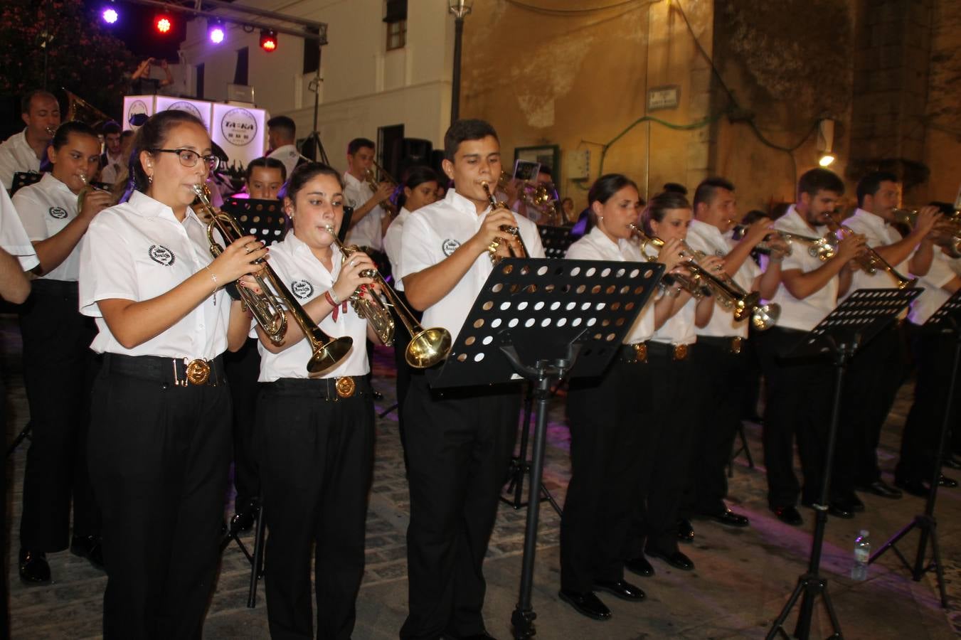 La Agrupación Musical Nuestro Padre Jesús Nazareno abrió el programa de la 'Velá' de Santa María con un magnífico concierto de verano. Todo un lujo disfrutar de la extraordinaria calidad de esta banda, al abrigo del templo visigodo jerezan. Sus integrantes deleitaron al público con la interpretación de obras muy conocidas, que invitaron a disfrutar de la fiesta que hoy prosigue en el Llano de Santa María. Esta mañana con los juegos populares: carrera de cintas en bicicleta, carrera de sacos, pucheros, juegos de agua..., junto a la apertura de la tradicional mesa de subasta y al servicio de barra para hacer frente al calor y disfrutar de sabores tradicionales, pues no ha faltado, como aperitivo, el pestorejo.