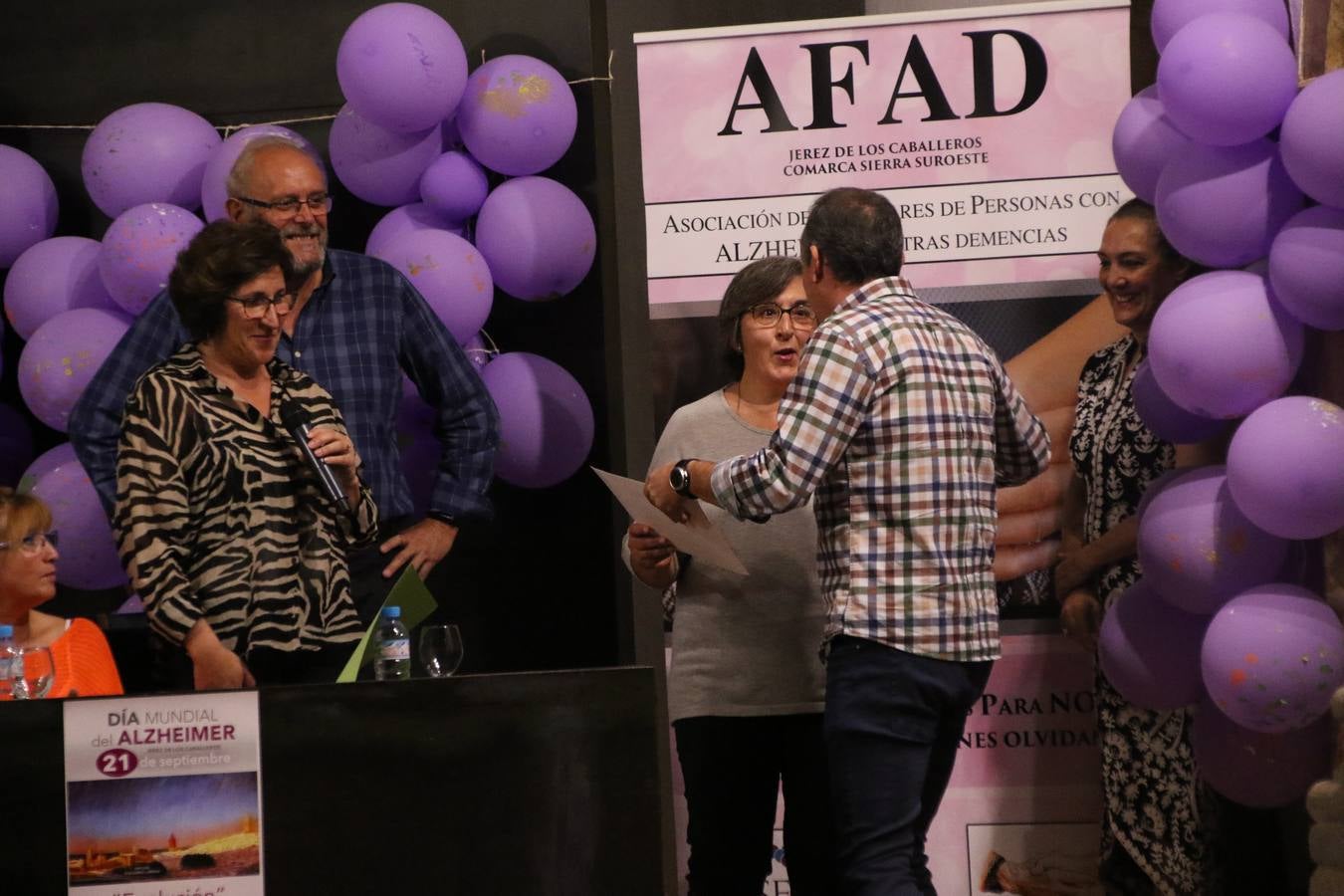 Ante las condiciones climatológicas adversas, el auditorio del Conventual San Agustín se convirtió en el mejor escenario para acoger las actividades que, con motivo del Día Mundial del Alzhéimer, la Asociación de Familiares de Personas con Alzheimer y otras Demencias de Jerez de los Caballeros y Comarca Sierra Suroeste (AFAD) había preparado en el municipio. Una gran pancarta con el lema 'Evolución', realizada por los alumnos del Colegio de Educación Especial 'Nuestra Señora de Aguasantas', presidió el escenario, y una marea de globos morados con distintos dibujos, realizados por los alumnos de los colegios 'Sotomayor y Terrazas' y 'El Rodeo', tiñó de color, empatía, sensibilidad y creatividad el citado auditorio.La jornada comenzó con la canción 'Estoy contigo' de la Oreja de Van Gogh. A continuación, tuvo lugar una mesa redonda en la que cinco personas contaron su testimonio en relación a esta enfermedad. Posteriormente, se dio paso a la lectura de un manifiesto; la entrega de diploma a las personas y colectivos colaboradores, y la lectura de dos cuentos infantiles.
