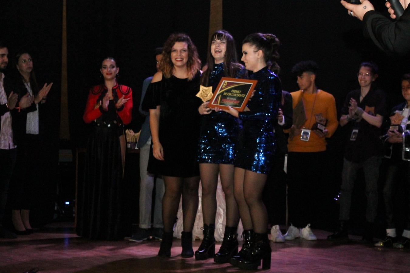 Con su premio.