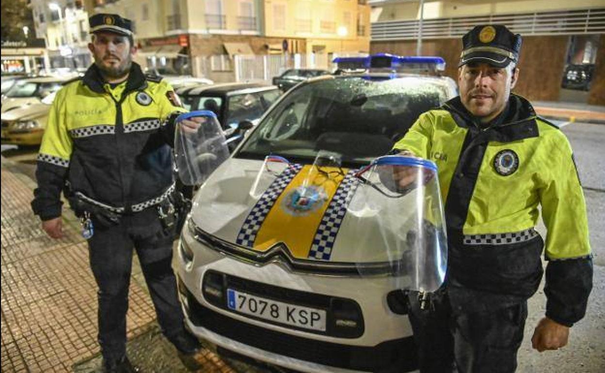 Dos agentes de la Policía Local de Badajoz muestran las viseras donadas por este grupo de extremeños.