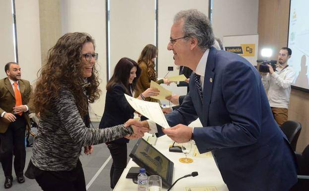 El rector de la UEX entrega un diploma a una becaria.