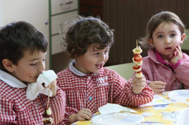 Niños comiendo fruta en clase.