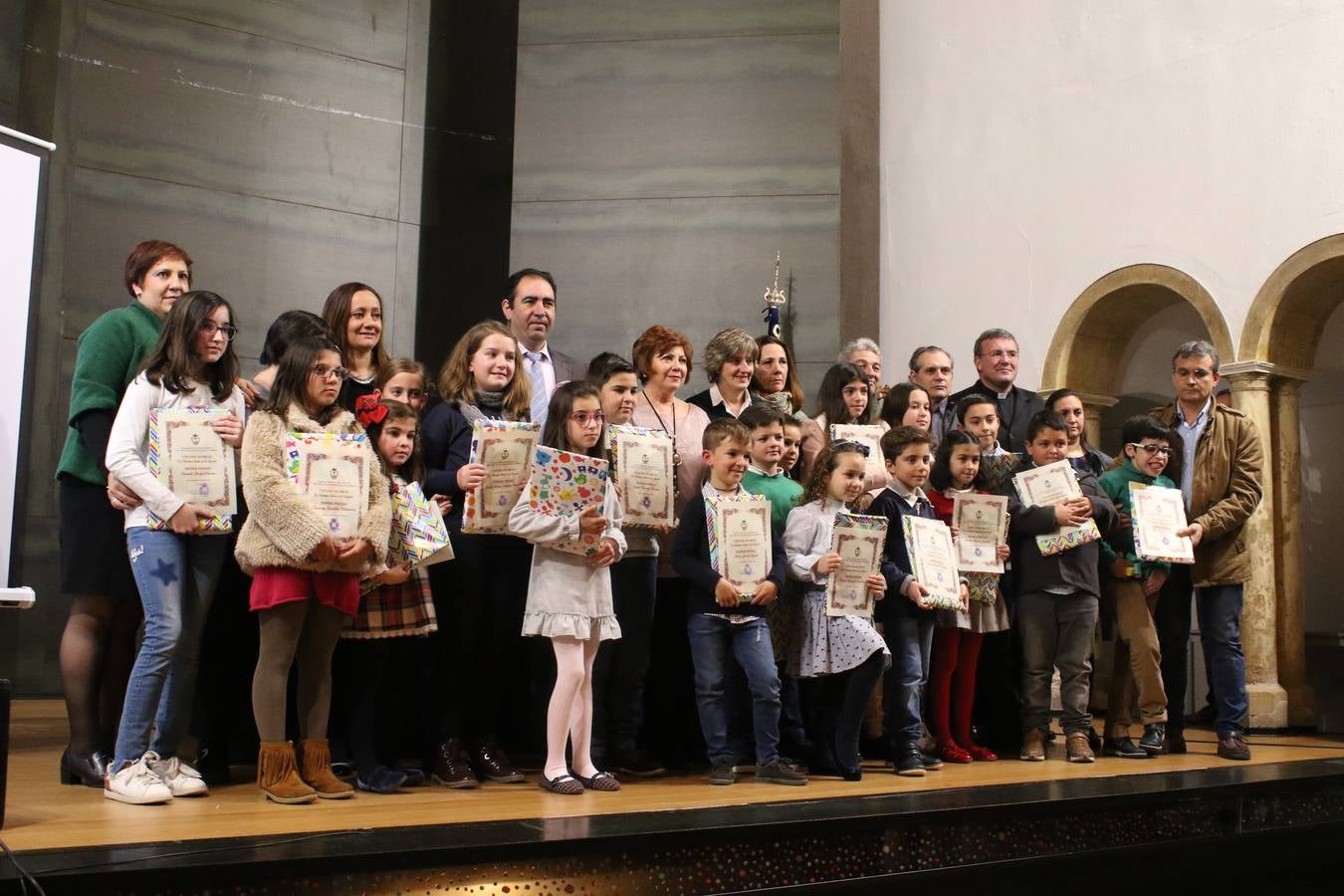 Representantes cofrades, alcaldesa, párroco, escolares premiados y Paqui Márquez, en una foto de grupo. Mari Paz Romero.
