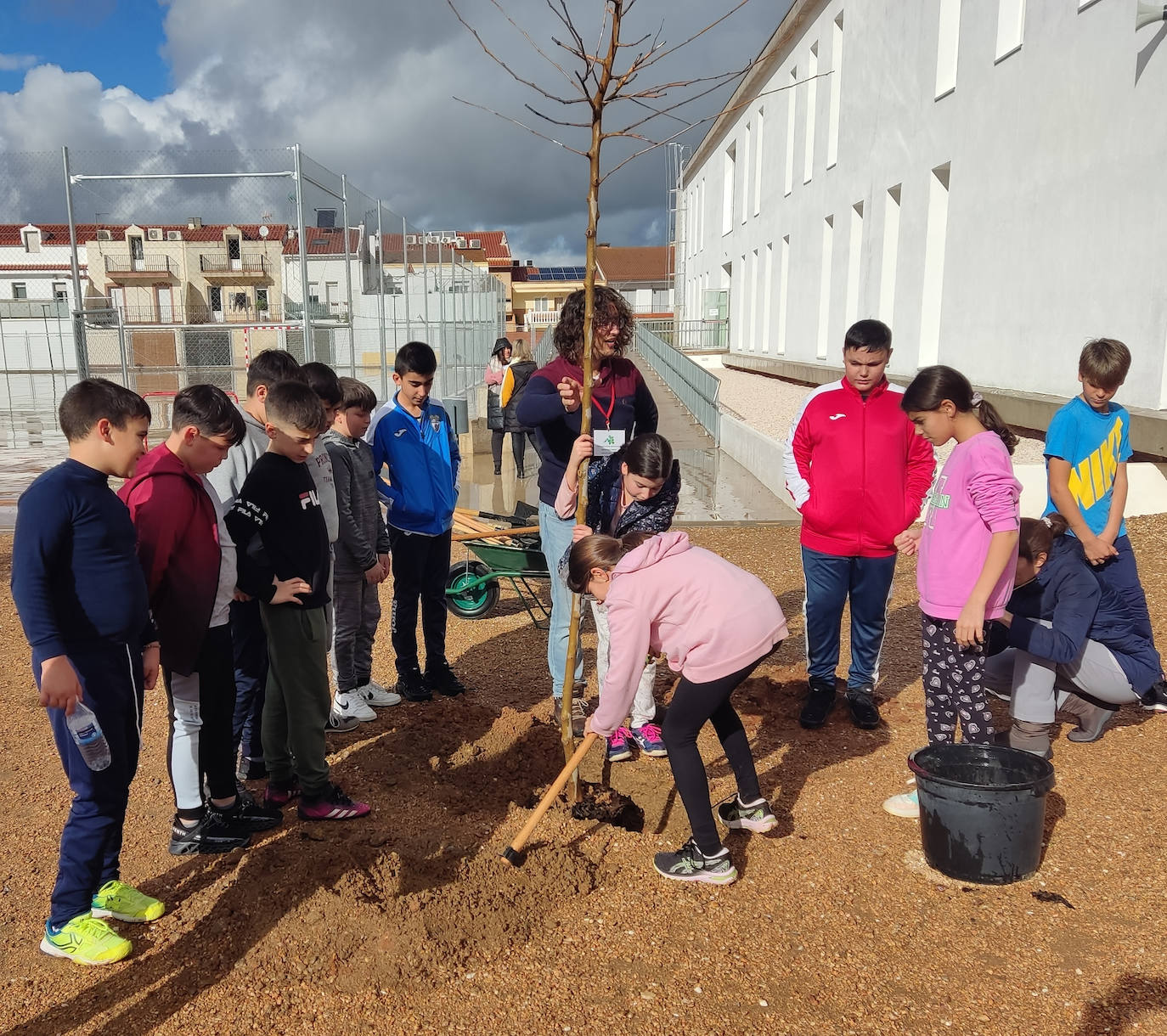 Dos alumnas plantan uno de los árboles