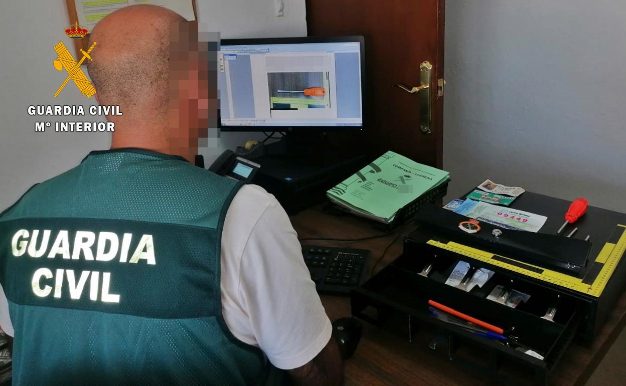 Un agente de la Guardia Civil investiga los delitos junto al material recuperado.