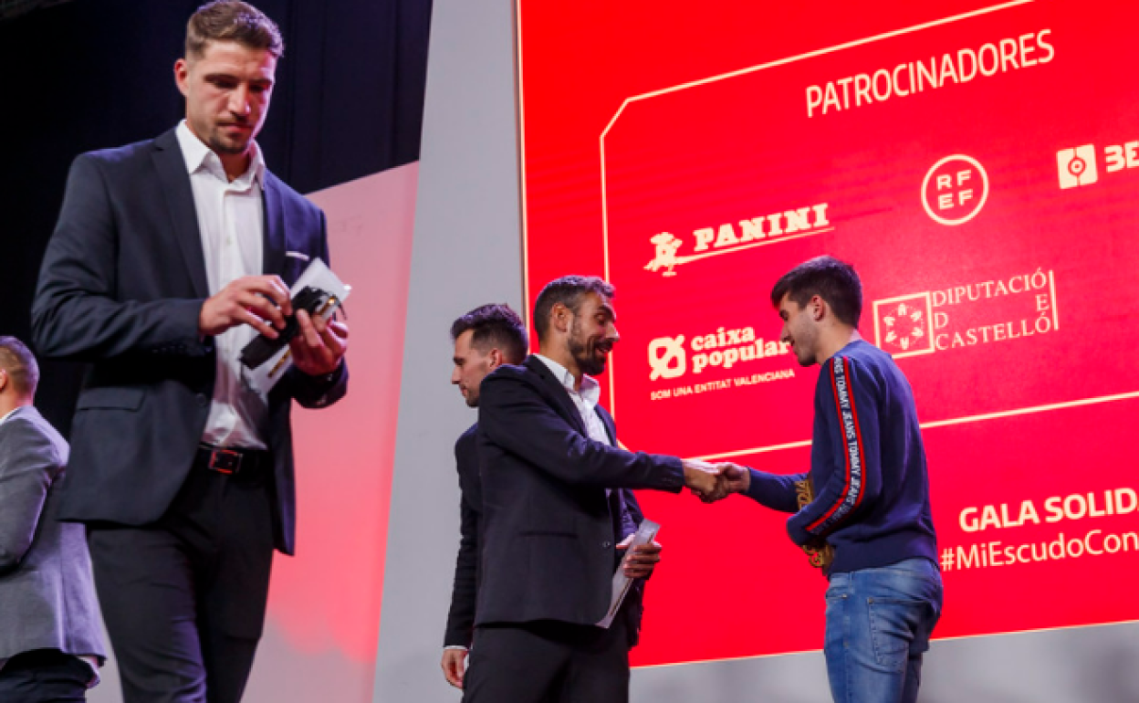 Carlos Martínez, en el fondo de la imagen a la izquierda, da la mano a otro premiado.
