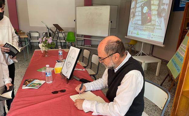 El escritor firma algunos libros a los alumnos.
