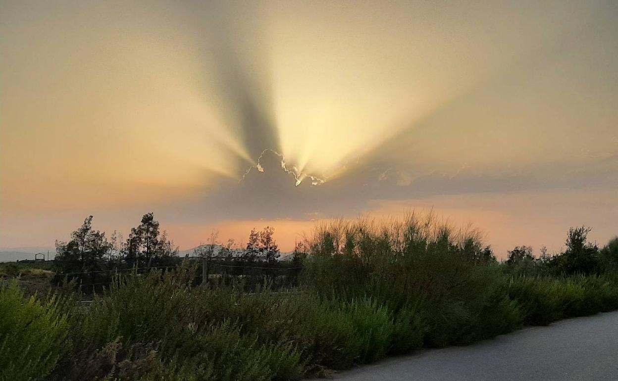 El sol implacable escondiendose tras una nube al atardecer 