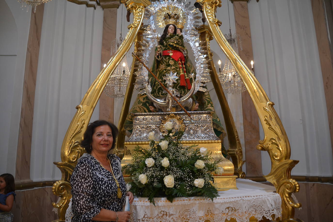 La mayordoma de la Virgen Mari carmen Tinoco jjunto a la imagen de la Virgen en su trono 