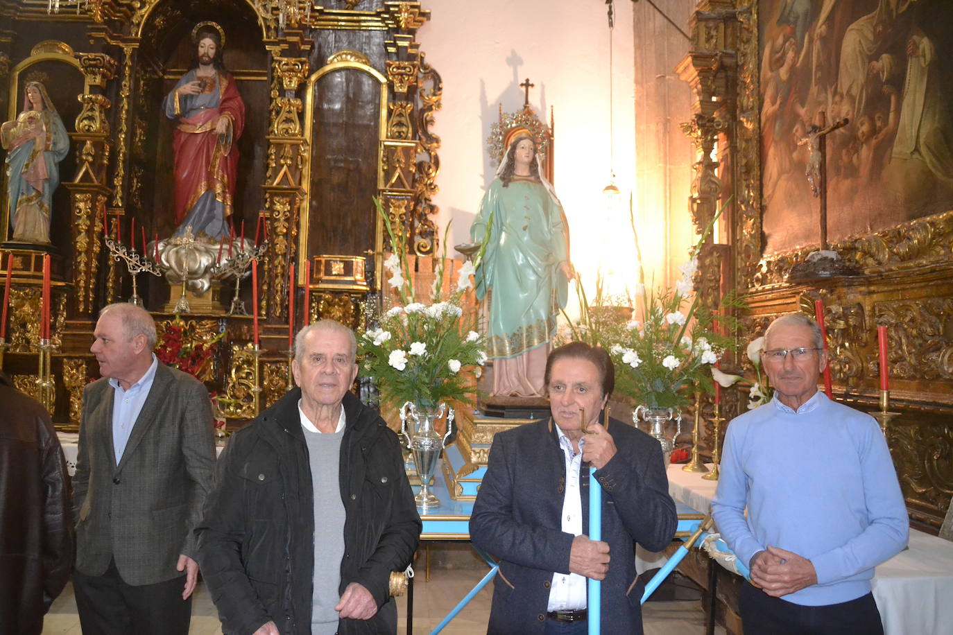 El hermano Mayor y otros cofrades, junto a las andas de la Santa