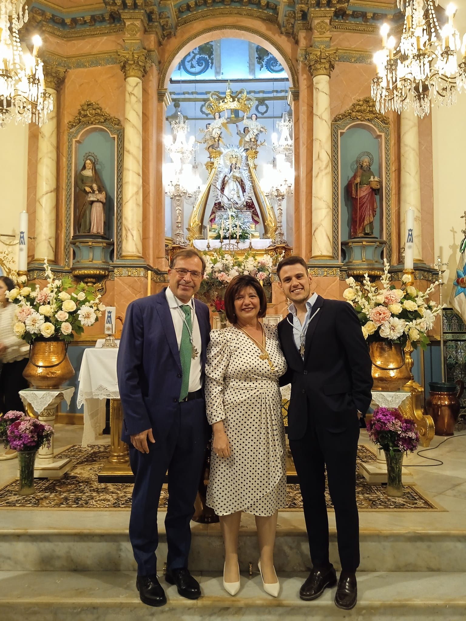 La mayordoma con dos de los nuevos miembros que juraron su cargo