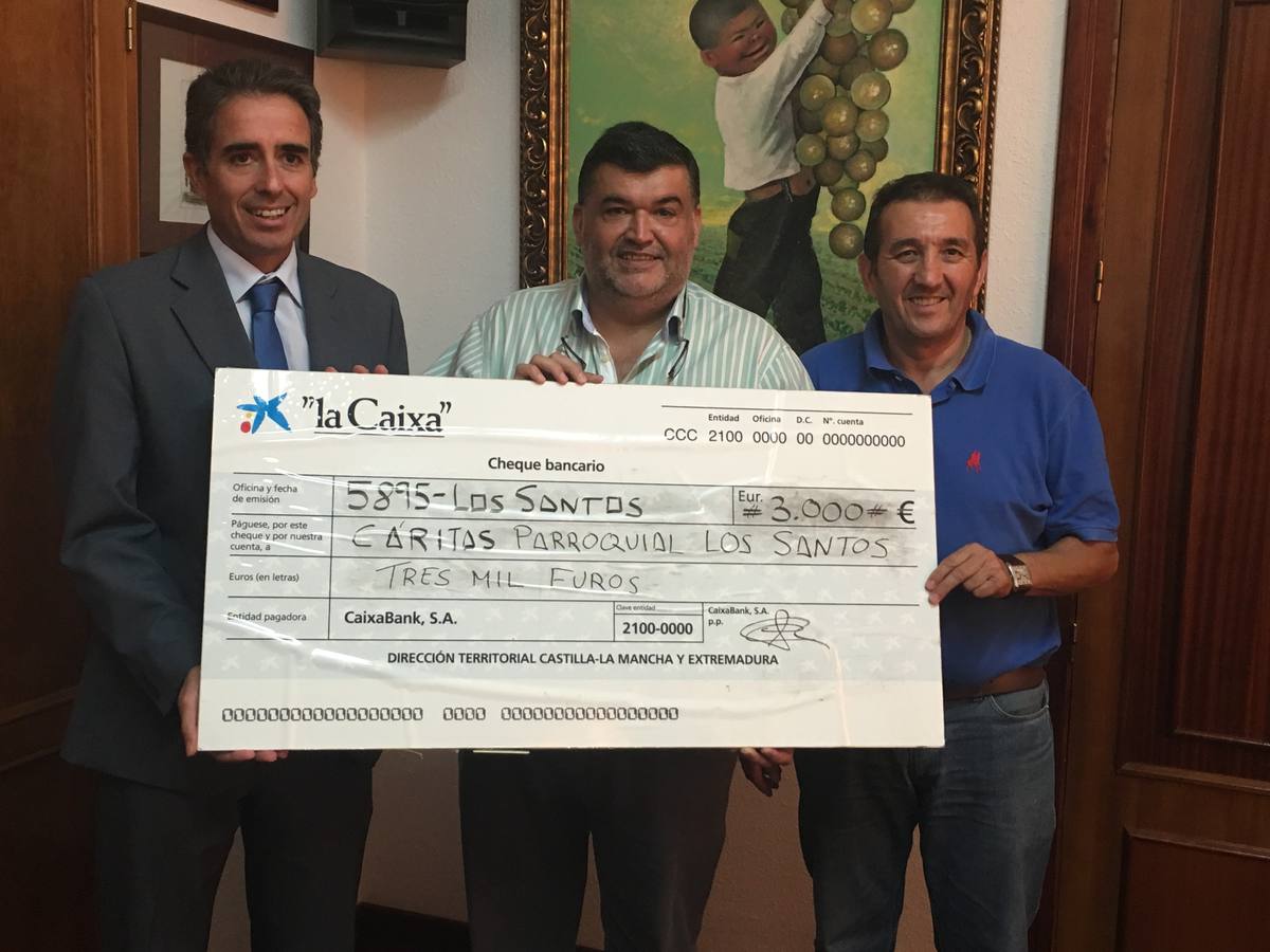 El director de la oficina de Caixabank en LosSantos junto al alcalde y el director de Cáritas en el momento de la entrega del cheque 