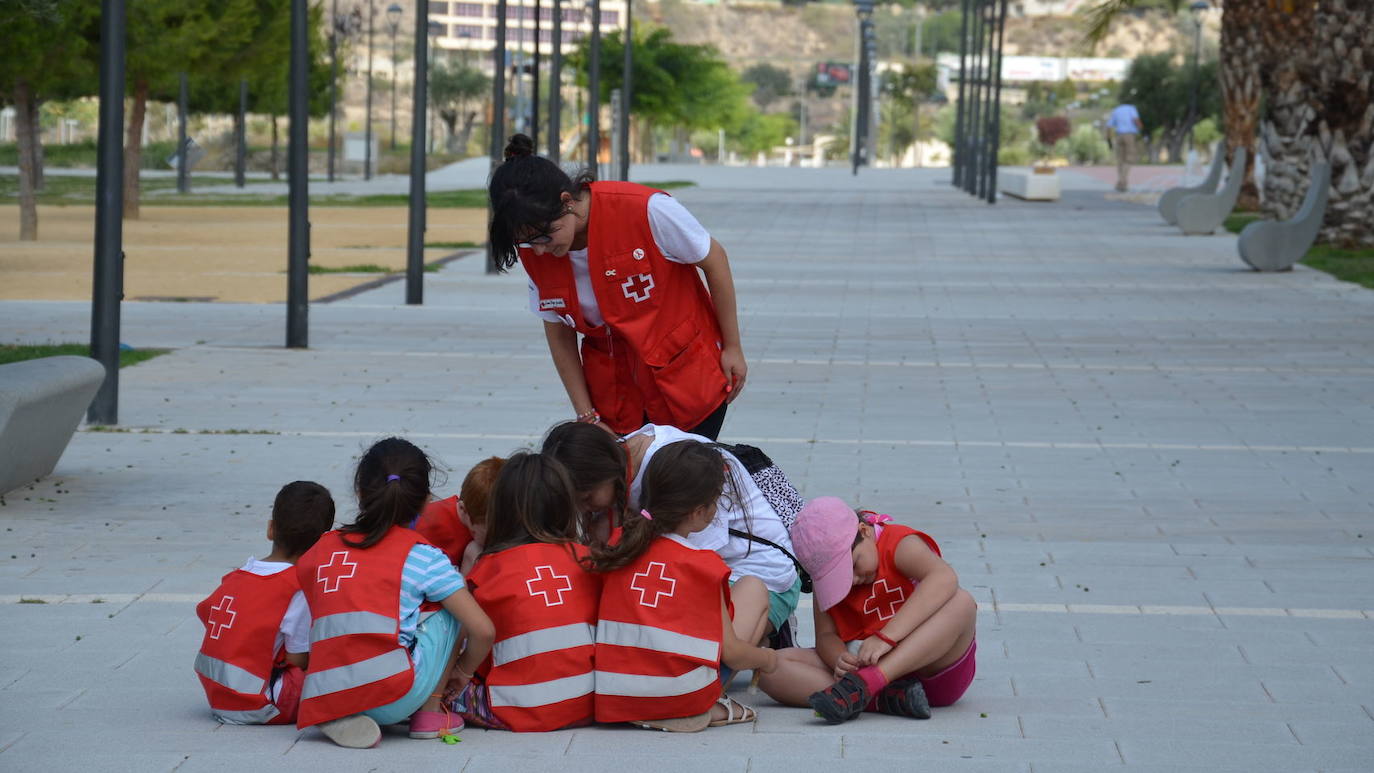 Monitora de Cruz Roja explicando a un grupo de niños