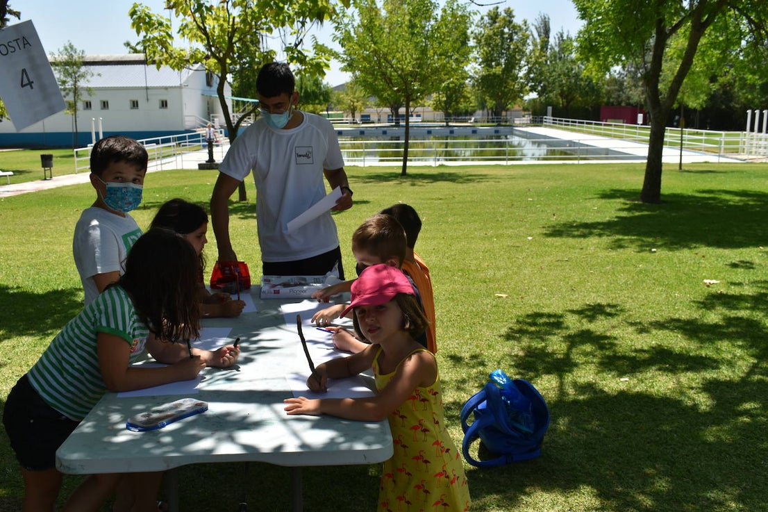 Los niños y niñas de la Escuela de Verano Cultural y Deportiva no paran en toda la mañana. Cada día realizan actividades deportivas, como jugar a los bolos, lanzar el frisbee, ejercicios de psicomotricidad,… o hacen manualidades para aprender historia, como el taller 'Crea tu dinosaurio', collares prehistóricos, huesos y disfraces neandertales, gorros con forma de dinosaurio, brazaletes y cruces de la época egipcia,… Los monitores también les organizan gymkanas y Juegos Olímpicos con tiros de anillas, salto de obstáculos, las conocidas como 'Pruebas de Hércules', carreras,… Además, han podido paliar el calor gracias a que han habilitado la piscina pequeña para ellos, debido a las altas temperaturas que está sufriendo la región. 