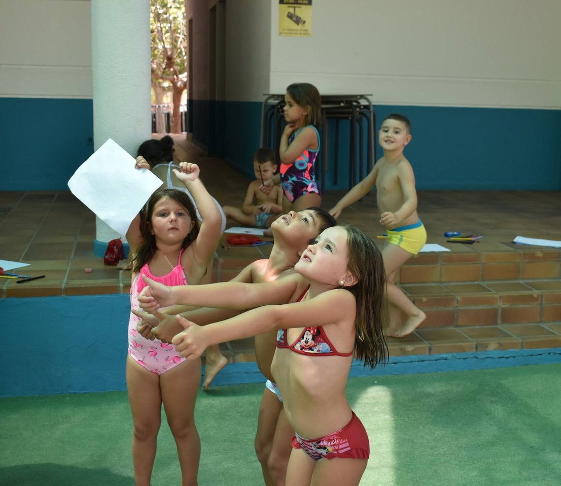 Los niños y niñas de la Escuela de Verano Cultural y Deportiva no paran en toda la mañana. Cada día realizan actividades deportivas, como jugar a los bolos, lanzar el frisbee, ejercicios de psicomotricidad,… o hacen manualidades para aprender historia, como el taller 'Crea tu dinosaurio', collares prehistóricos, huesos y disfraces neandertales, gorros con forma de dinosaurio, brazaletes y cruces de la época egipcia,… Los monitores también les organizan gymkanas y Juegos Olímpicos con tiros de anillas, salto de obstáculos, las conocidas como 'Pruebas de Hércules', carreras,… Además, han podido paliar el calor gracias a que han habilitado la piscina pequeña para ellos, debido a las altas temperaturas que está sufriendo la región. 