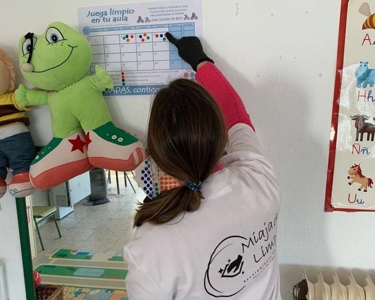 Una trabajadora del equipo de limpieza puntúa un aula 