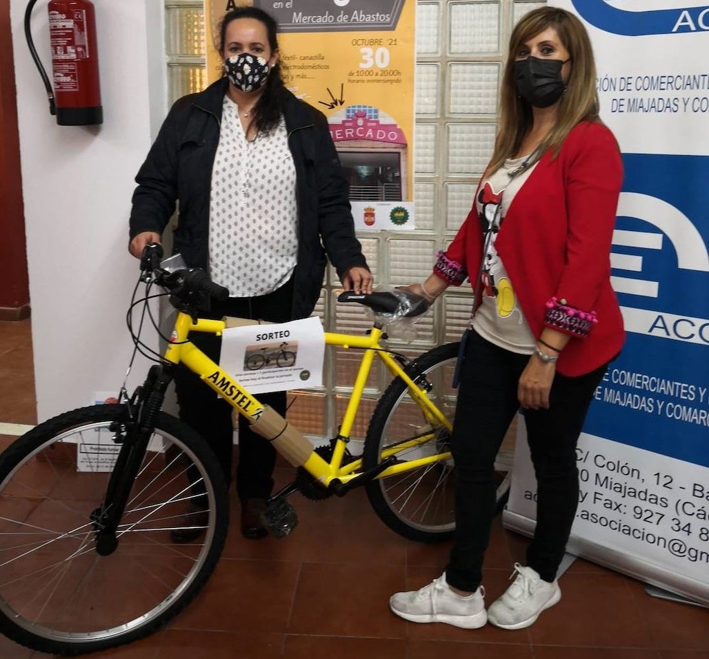 Mª Carmen Martínez (izq.) recoge la bicicleta de manos de Raquel Sánchez, presidenta de Acomic (dcha.) 