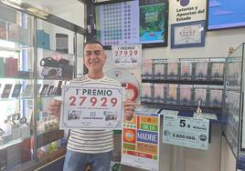 Nemesio Parras, dueño de Bazar Mayoral, posa con el número del primer premio repartido en la Lotería Nacional