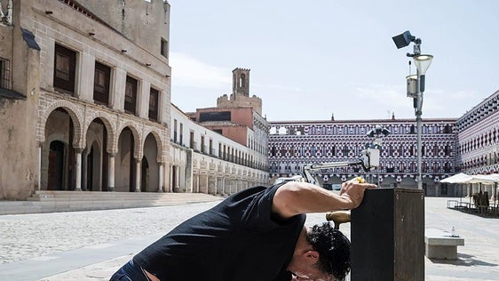Un vecino se refresca en una fuente durante una ola de calor.
